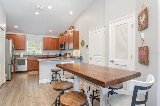 a kitchen with a table chairs sink and cabinets