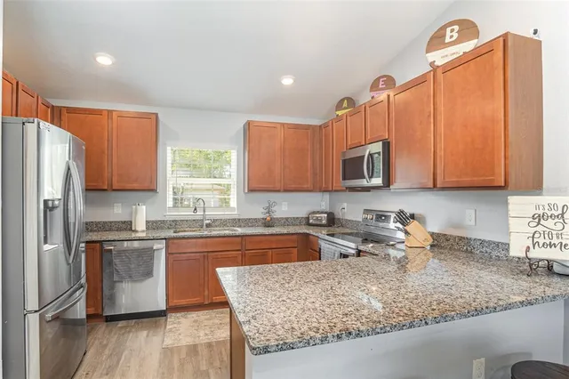 a kitchen with stainless steel appliances granite countertop a sink stove and refrigerator