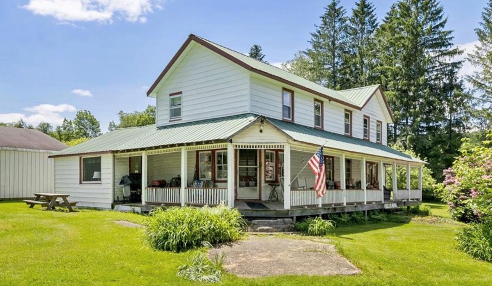 2018 Beaverkill Road Livingston Manor, NY 12758 - Photo 28 of 30 a view of a white house with a large windows and a yard table and chairs