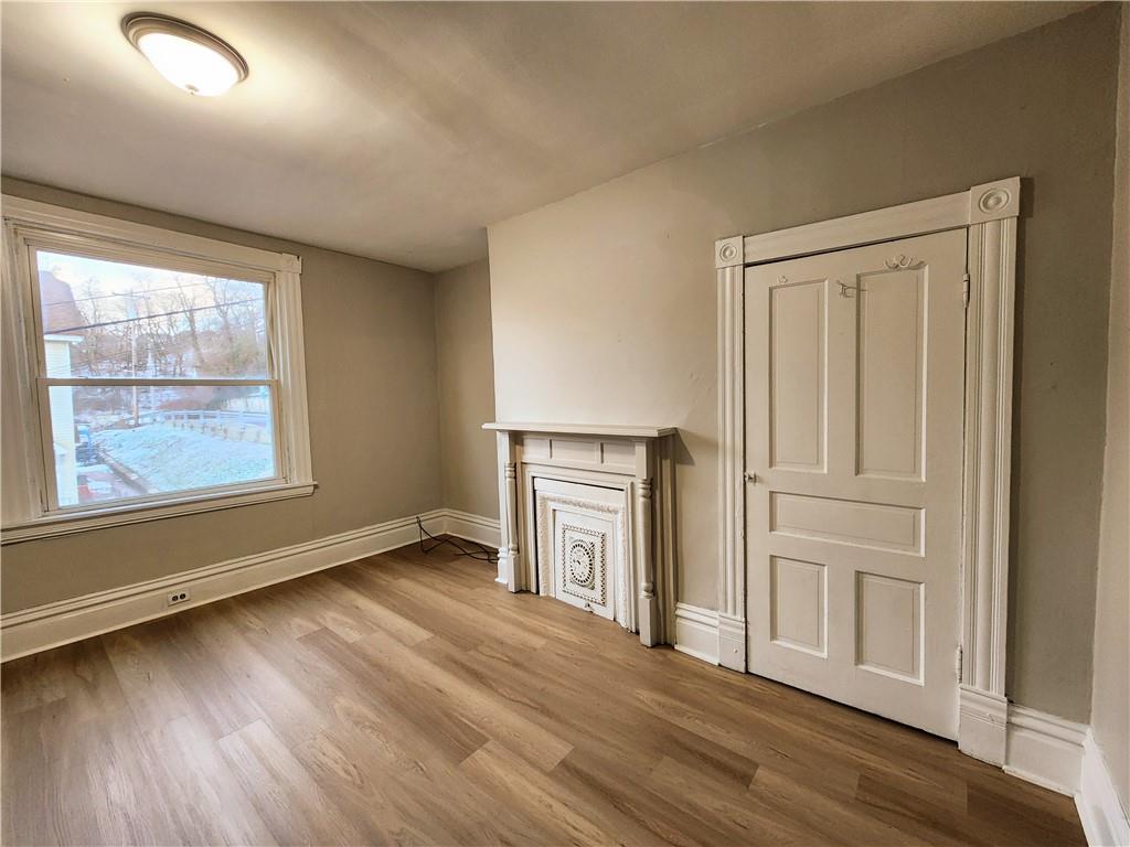 124 Cutler Street McKees Rocks, PA 15136 - Photo 3 of 9 an empty room with wooden floor cabinet and windows