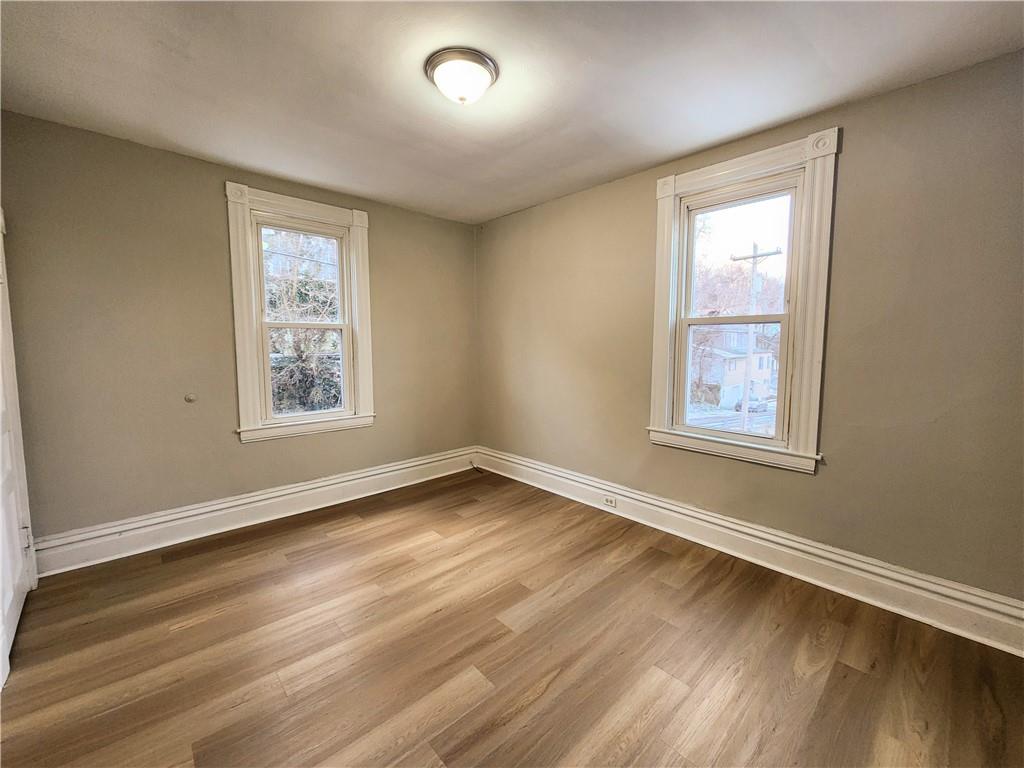 124 Cutler Street McKees Rocks, PA 15136 - Photo 4 of 9 a view of an empty room with wooden floor and a window