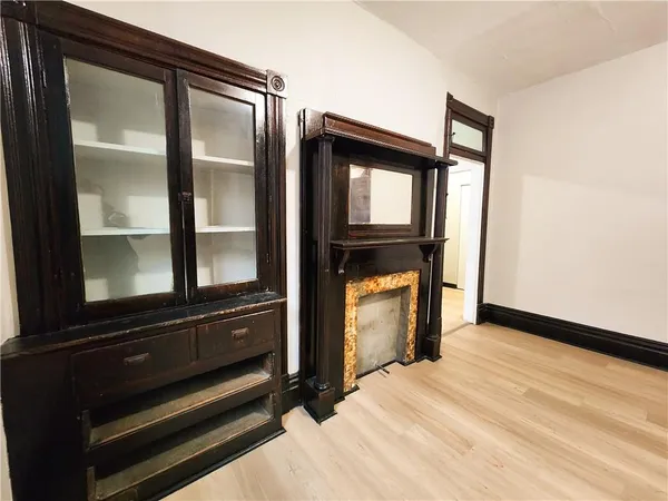 a view of empty room with wooden floor and windows