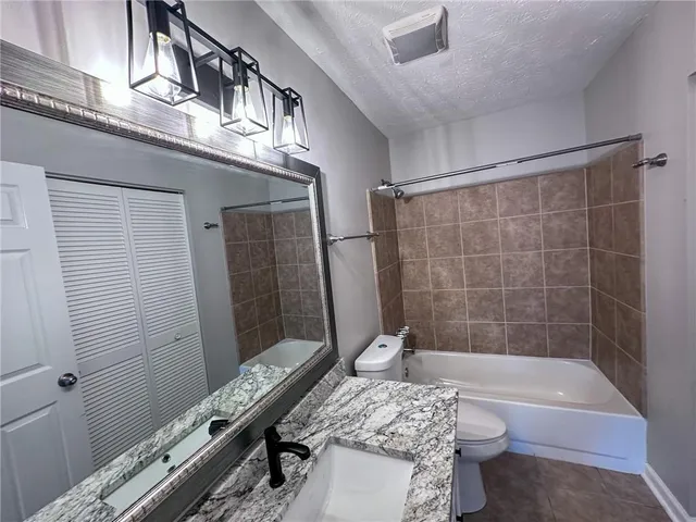 a bathroom with a granite countertop bathtub a sink and a shower