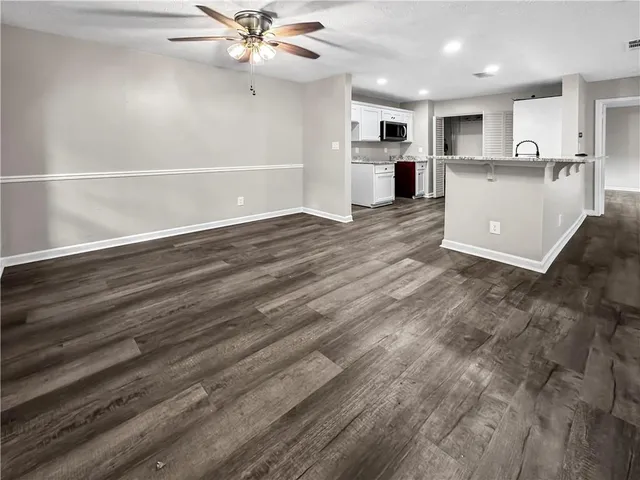 a view of a kitchen with a sink and dishwasher a refrigerator with wooden floor