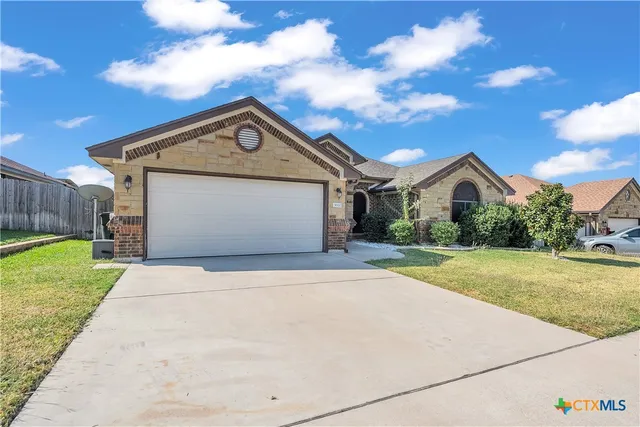 a front view of house with yard and garage