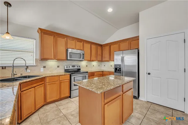a kitchen with stainless steel appliances granite countertop a sink stove and refrigerator