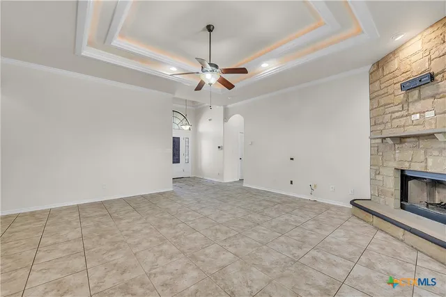 a view of empty room with fireplace and fan