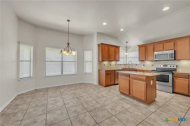 a kitchen with stainless steel appliances granite countertop a stove sink and cabinets