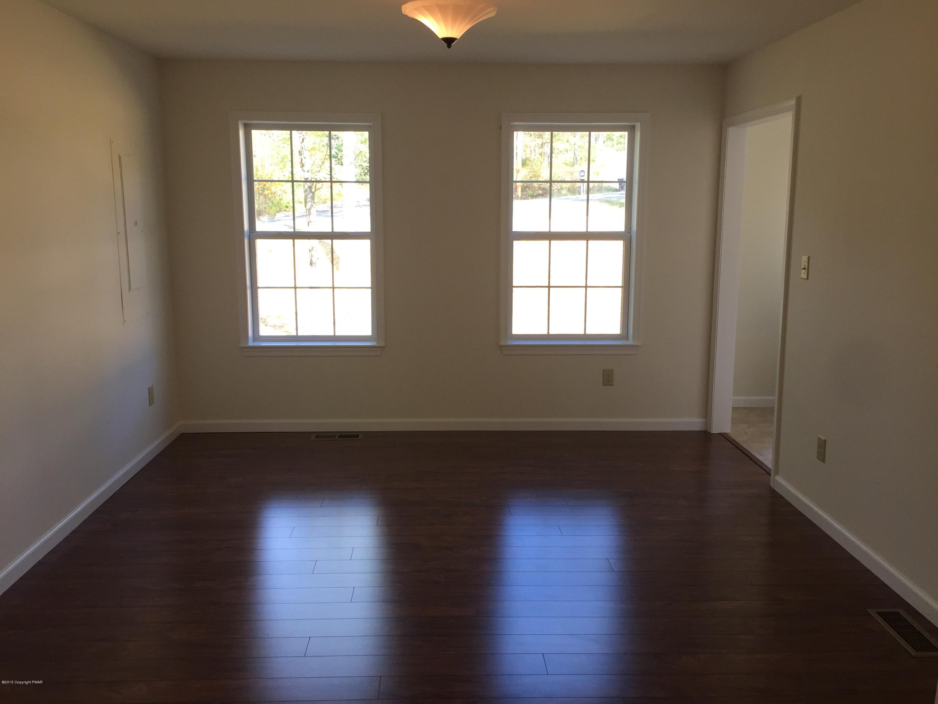 168 Whitetail Road Henryville, PA 18332 - Photo 8 of 28 an empty room with wooden floor and windows