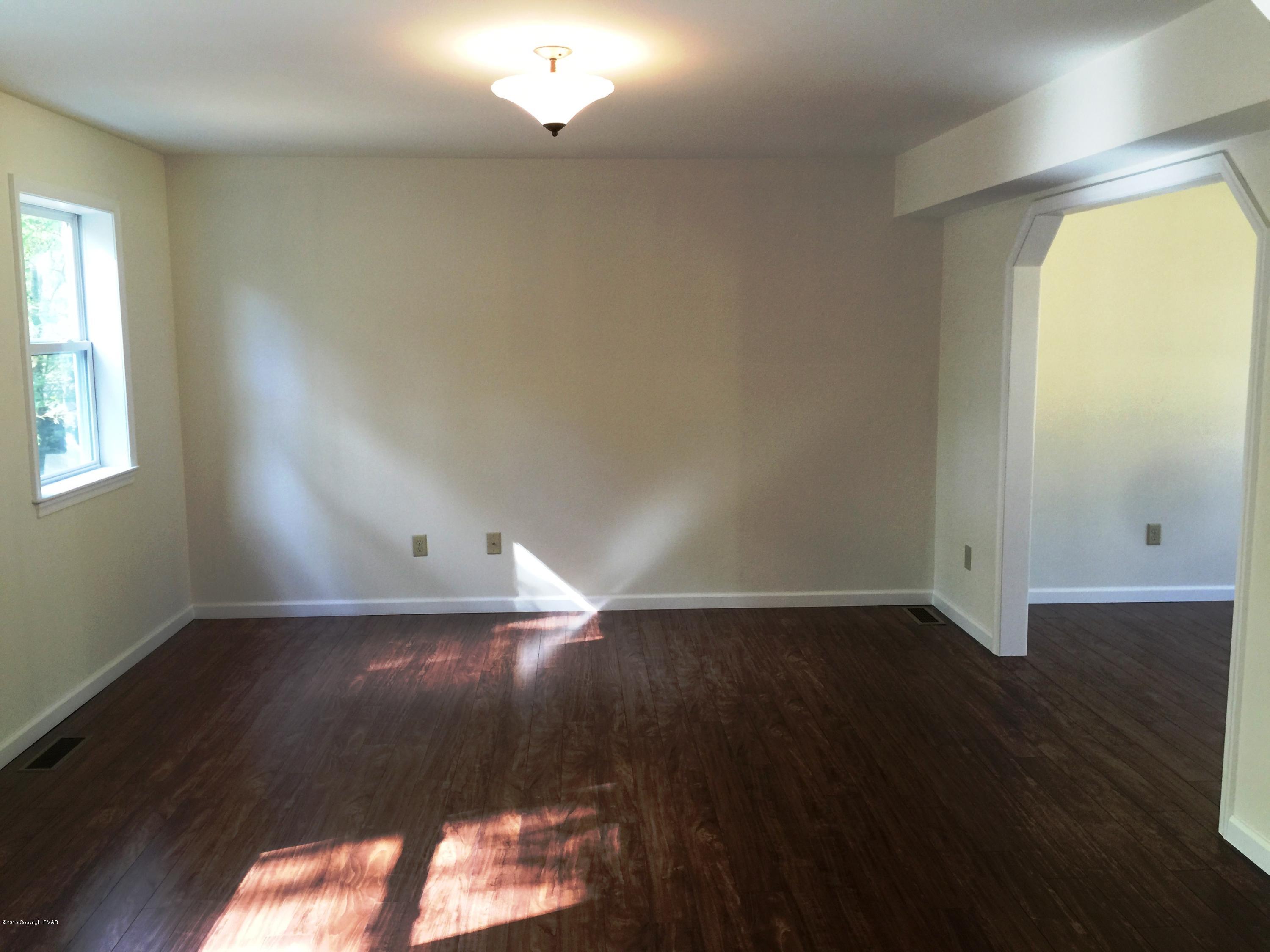 168 Whitetail Road Henryville, PA 18332 - Photo 9 of 28 an empty room with wooden floor and windows