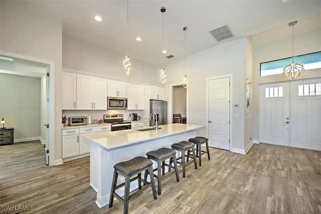 a kitchen with white cabinets and stainless steel appliances