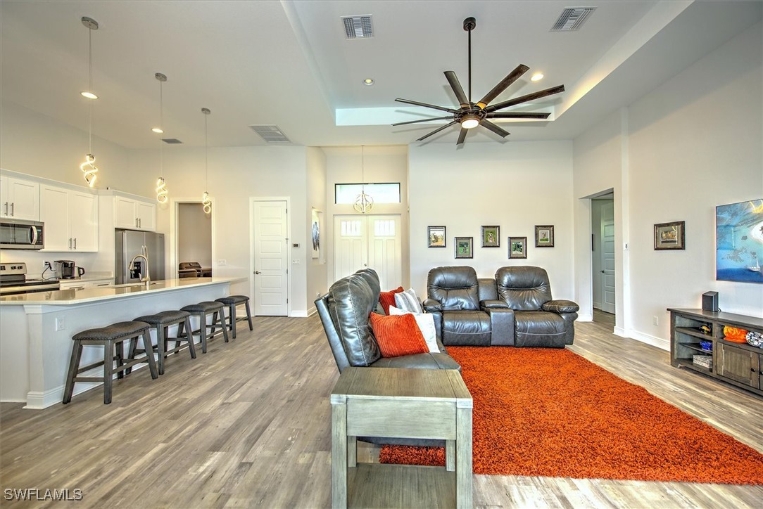 3527 Southwest 4th Lane Cape Coral, FL 33991 - Photo 6 of 18 a living room with furniture kitchen view and a wooden floor
