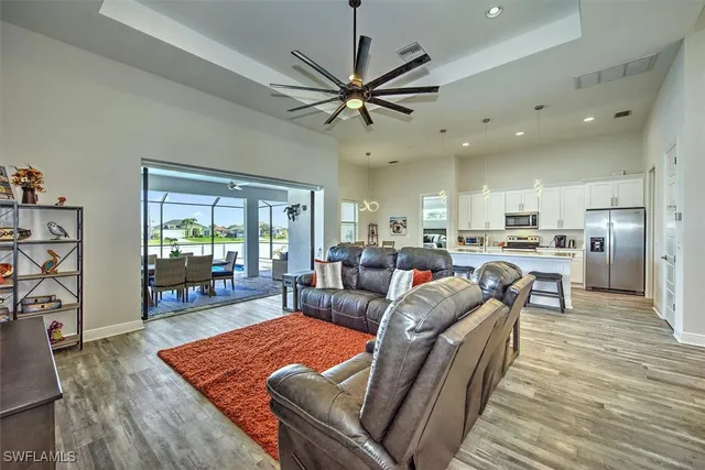 a living room with furniture kitchen view and a wooden floor