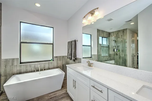 a bathroom with a large tub sink and mirror