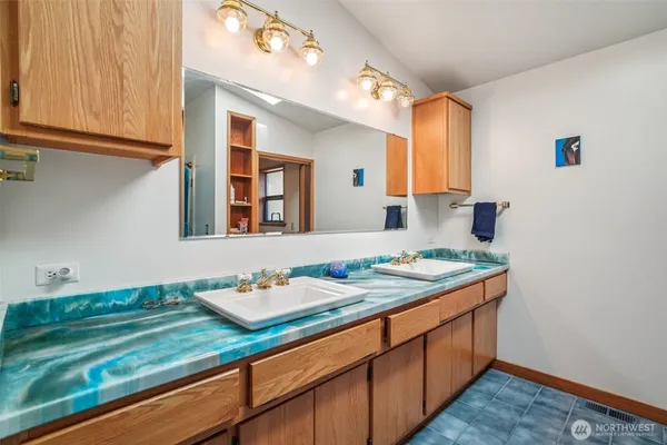 a bathroom with a granite countertop sink and a mirror