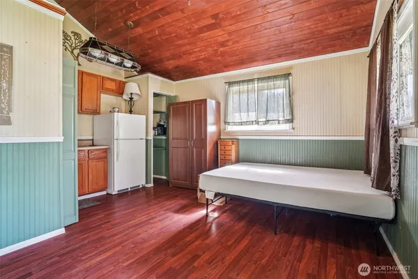 a kitchen with a refrigerator and wooden floor