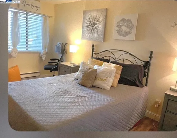 a bedroom with bed and painting on the wall