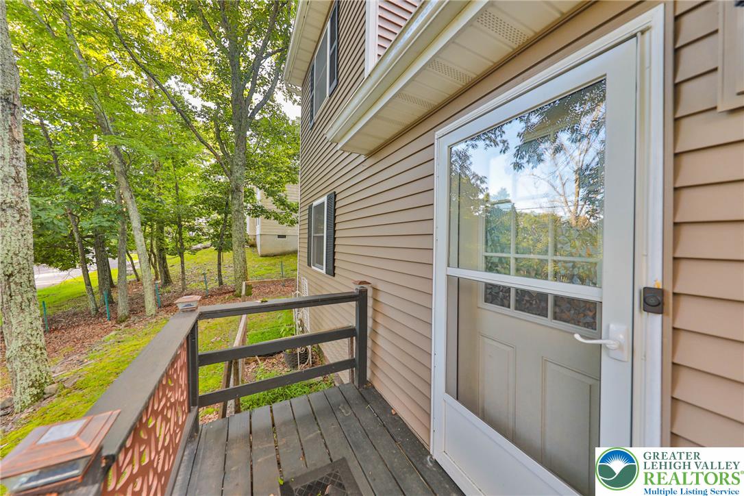 2114 Lakeview Road Bushkill, PA 18324 - Photo 64 of 83 An elevated wood porch overlooks a quiet yard surrounded by dense, mature trees.