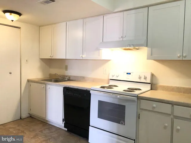 a kitchen with granite countertop cabinets stainless steel appliances and a sink