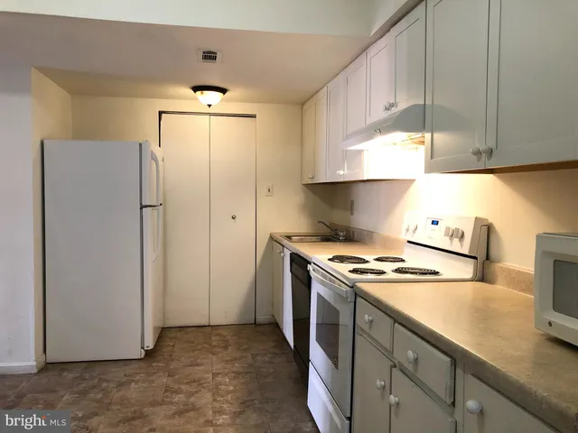 a kitchen with a stove cabinets and refrigerator