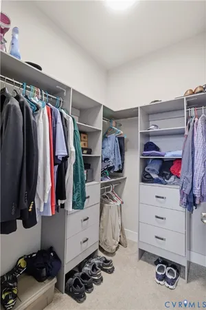 a view of walk in closet with clothes and shoes