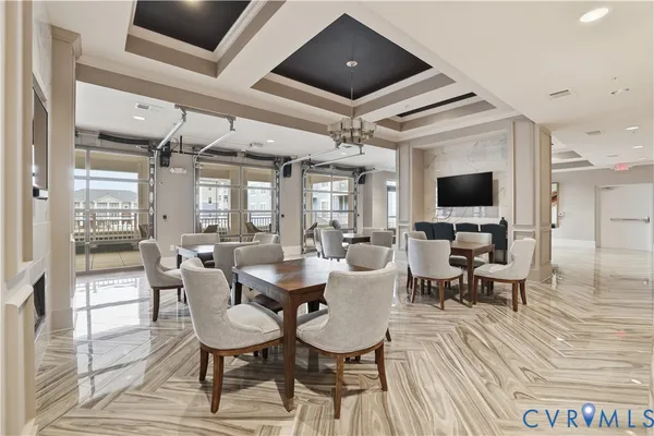 a living room with furniture a flat screen tv and a floor to ceiling window