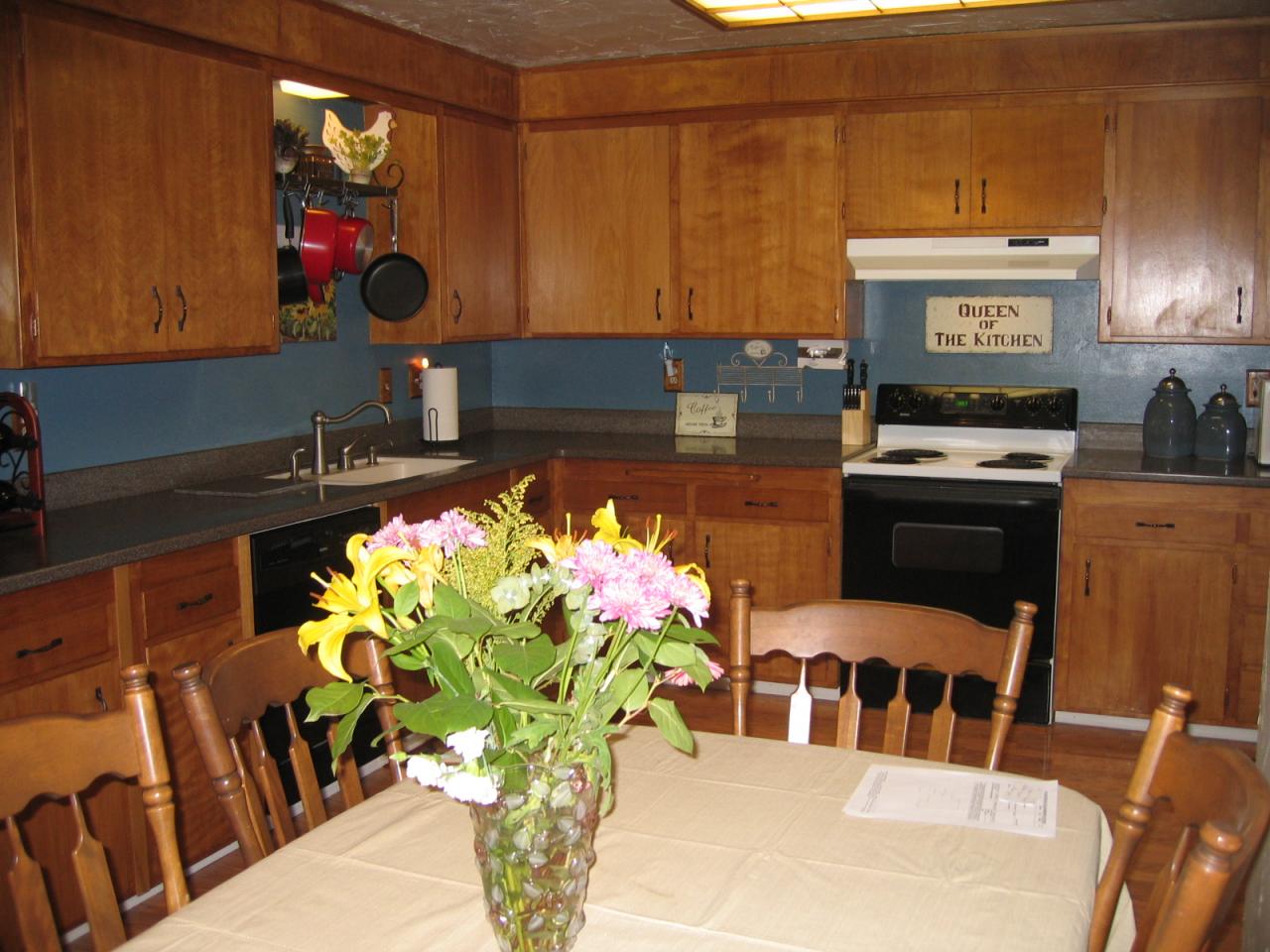 11554 Quartz Hill Road Redding, CA 96003 - Photo 3 of 28 a kitchen with a stove a sink cabinetry and a dining table