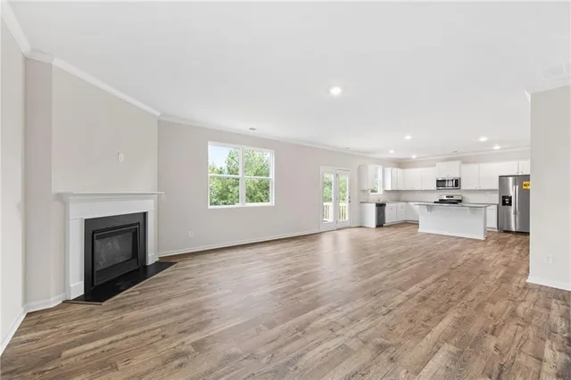 a view of kitchen with kitchen island wooden floors and stainless steel appliances