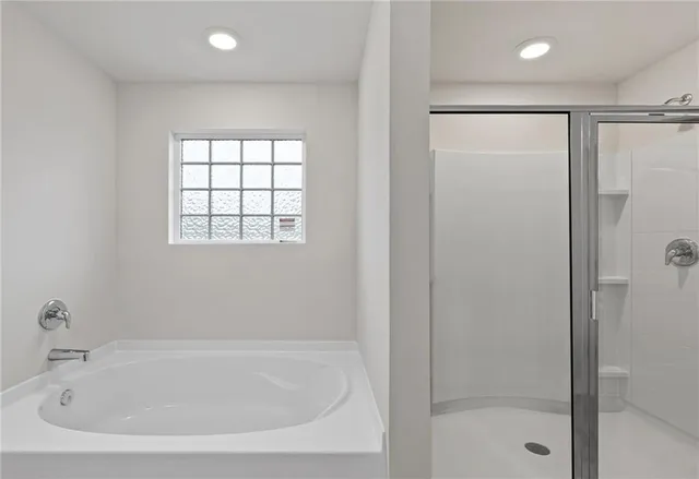 a white bath tub sitting next to a shower