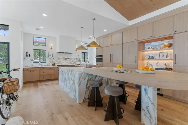 a kitchen with stainless steel appliances granite countertop a table chairs sink stove and cabinets