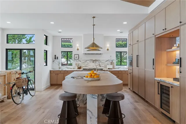a kitchen with stainless steel appliances granite countertop a table chairs refrigerator and wooden floor