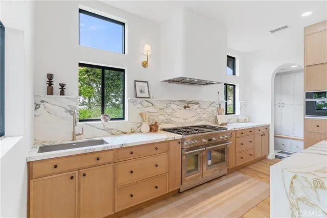 a kitchen with granite countertop white cabinets and white stainless steel appliances