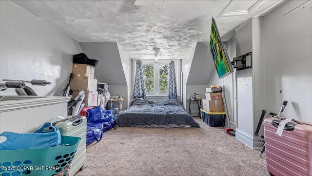 a bedroom with furniture and a flat screen tv