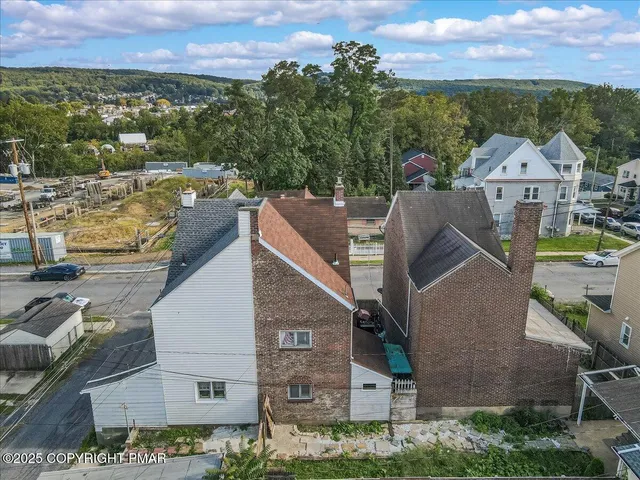 a view of a brick house with large windows and a table and chairs