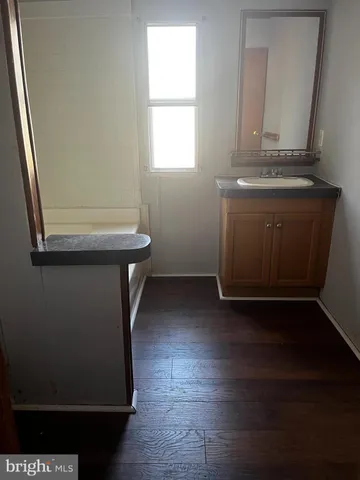 a view of a room with wooden floor and a sink