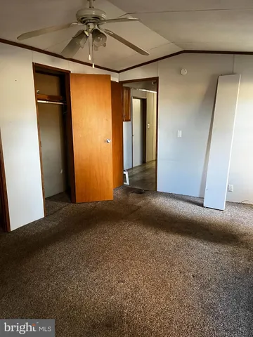 a view of an empty room with a chandelier fan
