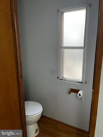 a white toilet sitting next to a window