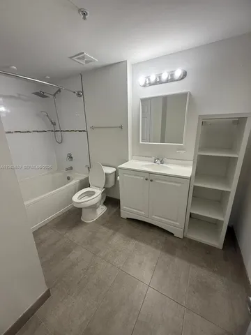 a bathroom with a white tub shower vanity and a sink