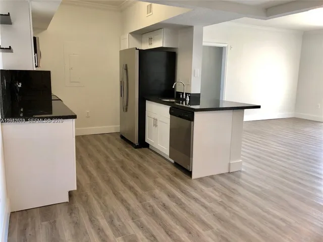 a kitchen with a refrigerator and a stove top oven