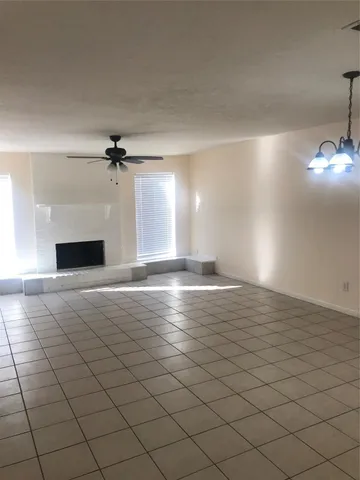 a view of an empty room and chandelier