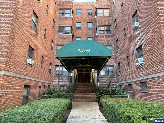 a kitchen with stainless steel appliances granite countertop a refrigerator a stove top oven a sink dishwasher and white cabinets with wooden floor