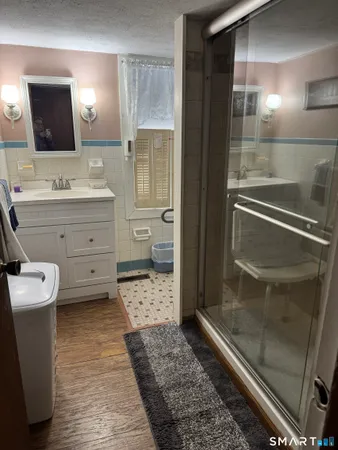 a bathroom with a sink a toilet and shower