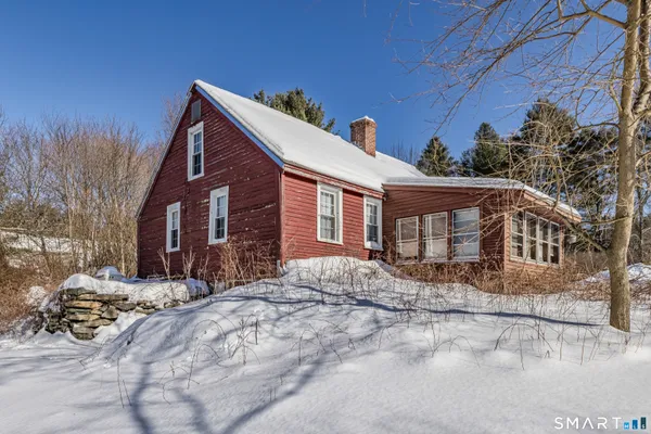 a front view of a house with a yard covered with snow