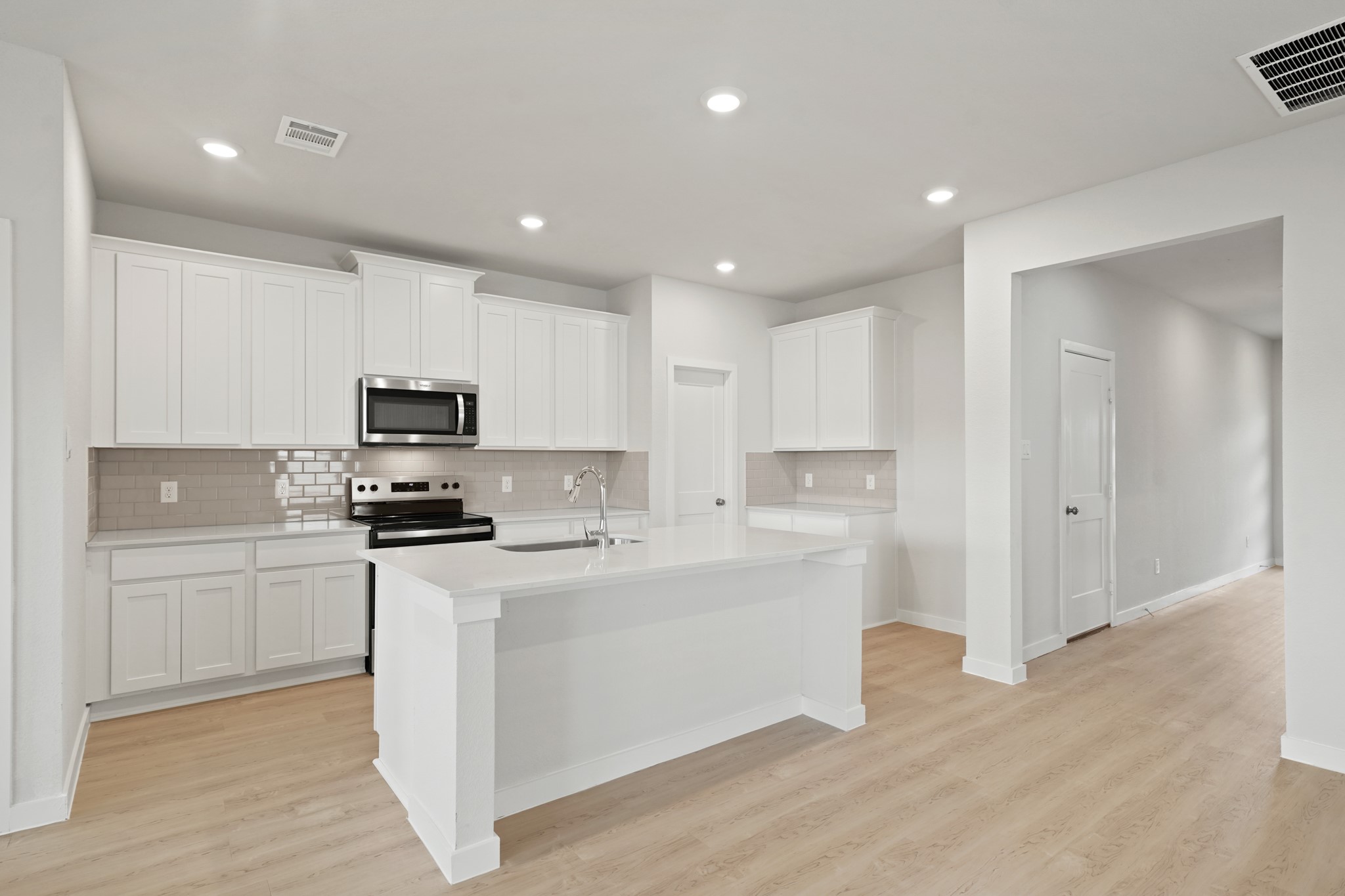 2402 Forshire Road Conroe, TX 77306 - Photo 7 of 24 a kitchen with stainless steel appliances a stove top oven a sink a refrigerator and cabinets