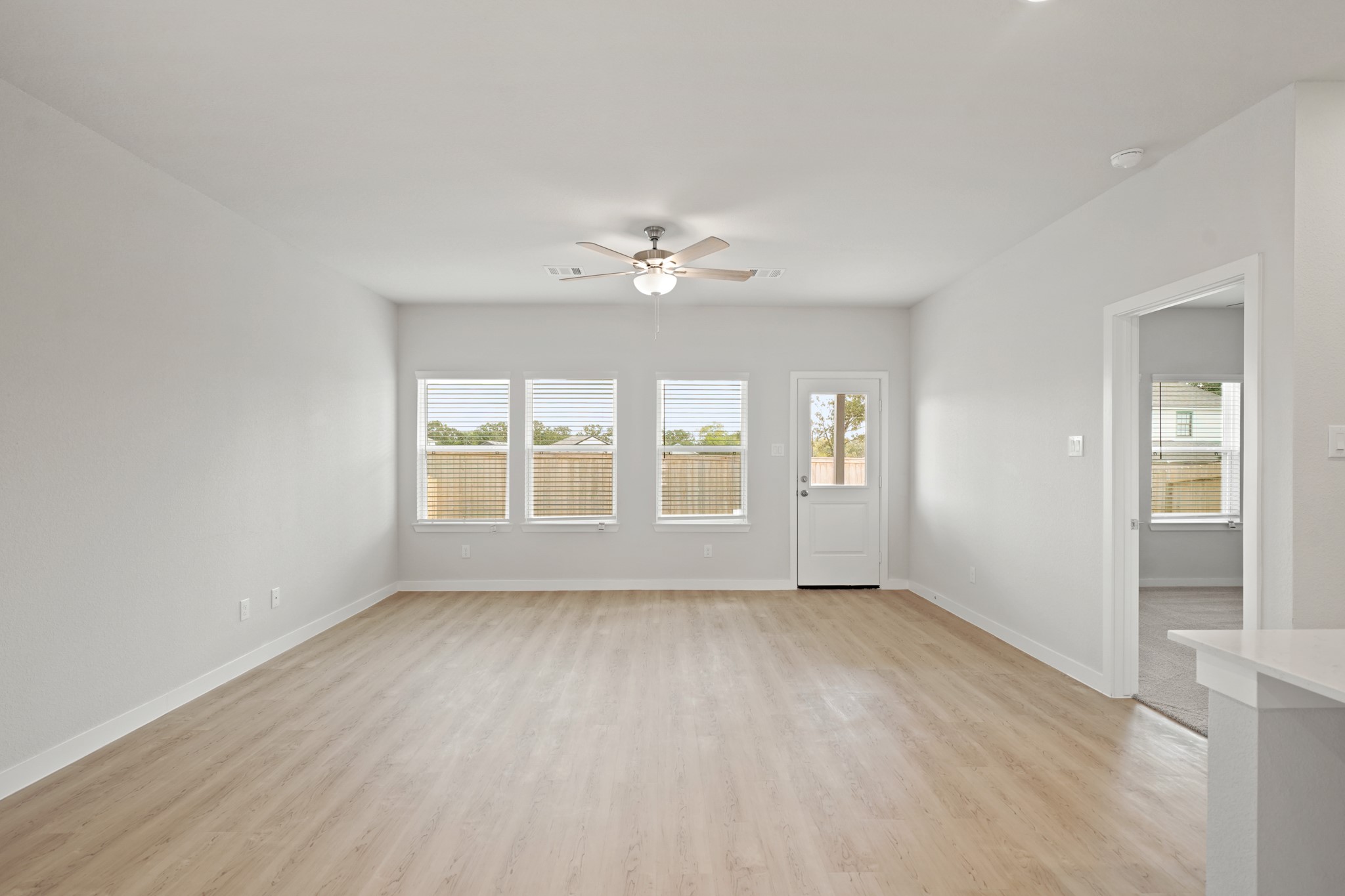 2402 Forshire Road Conroe, TX 77306 - Photo 9 of 24 an empty room with chandelier fan and windows