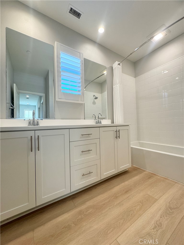 179 Hargrove Irvine, CA 92620 - Photo 18 of 27 a spacious bathroom with a double vanity sink a mirror and a bathtub