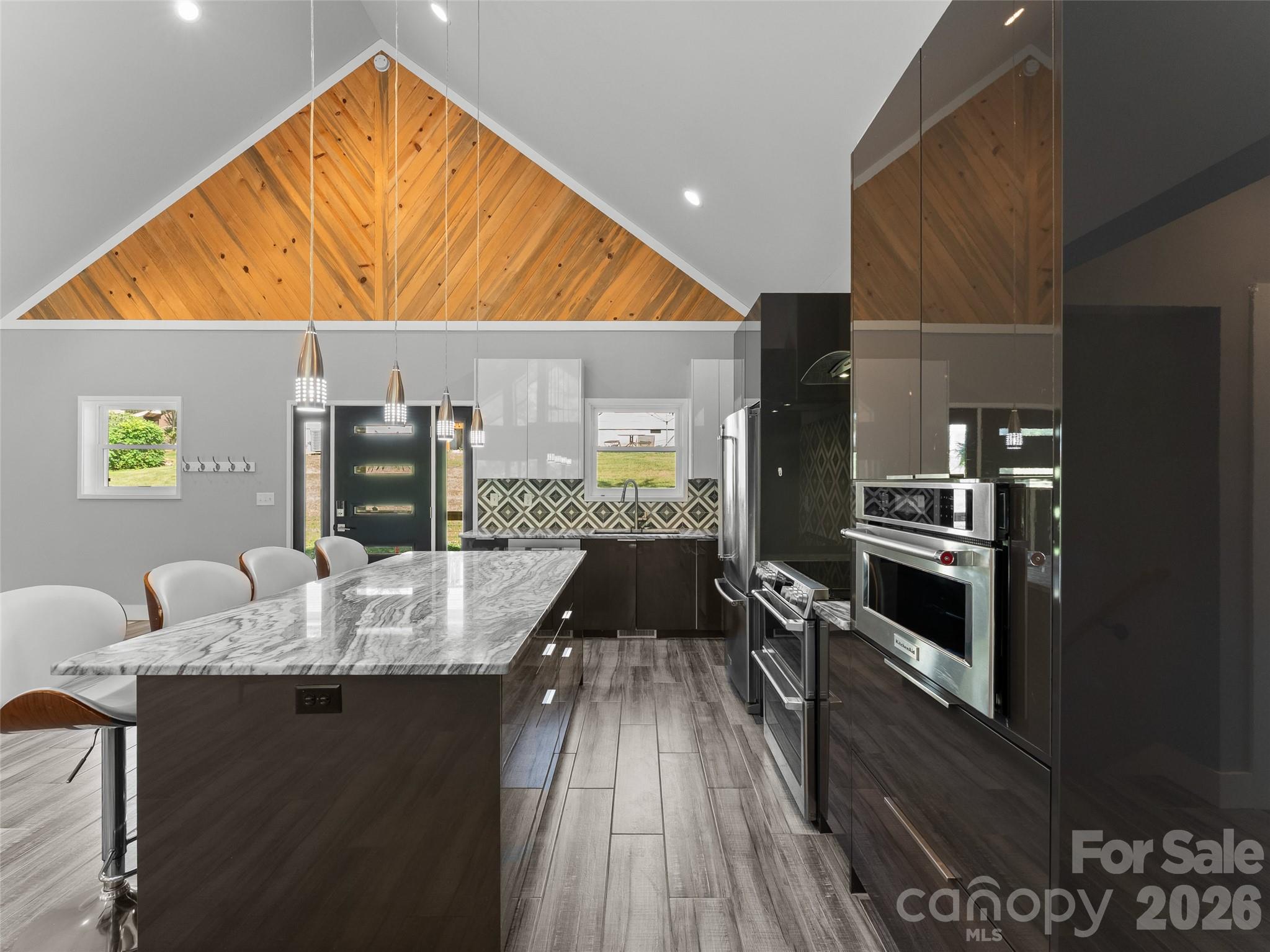 123 Israel Road Candler, NC 28715 - Photo 10 of 44 a kitchen with stainless steel appliances kitchen island granite countertop a table chairs in it and wooden floors