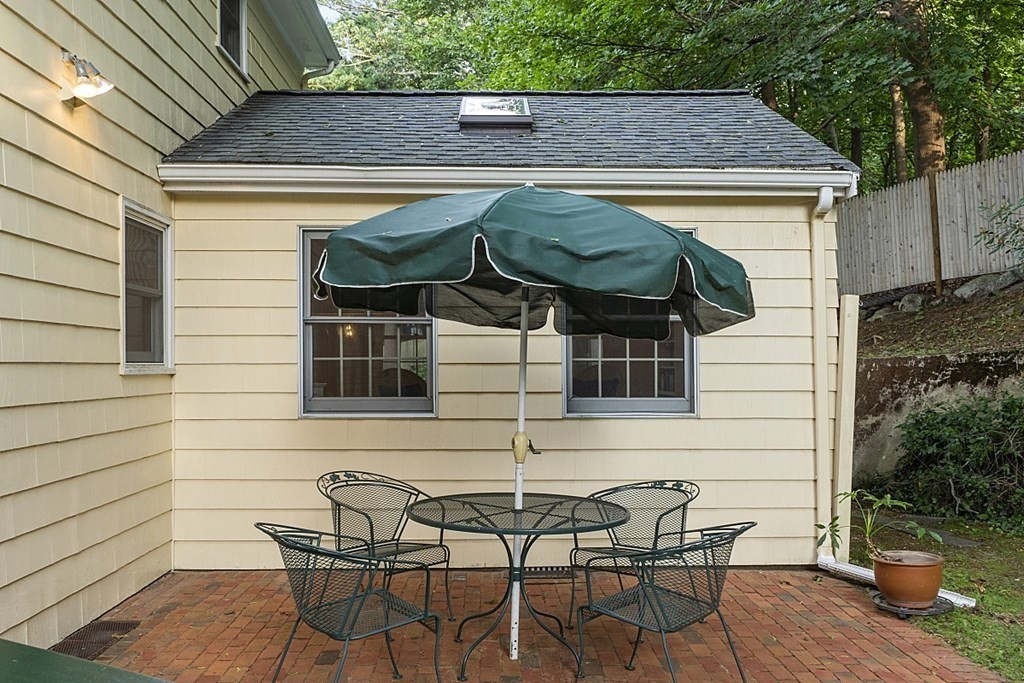 5 Alpine Circle Wakefield, MA 01880 - Photo 5 of 42 a view of a patio with table and chairs under an umbrella