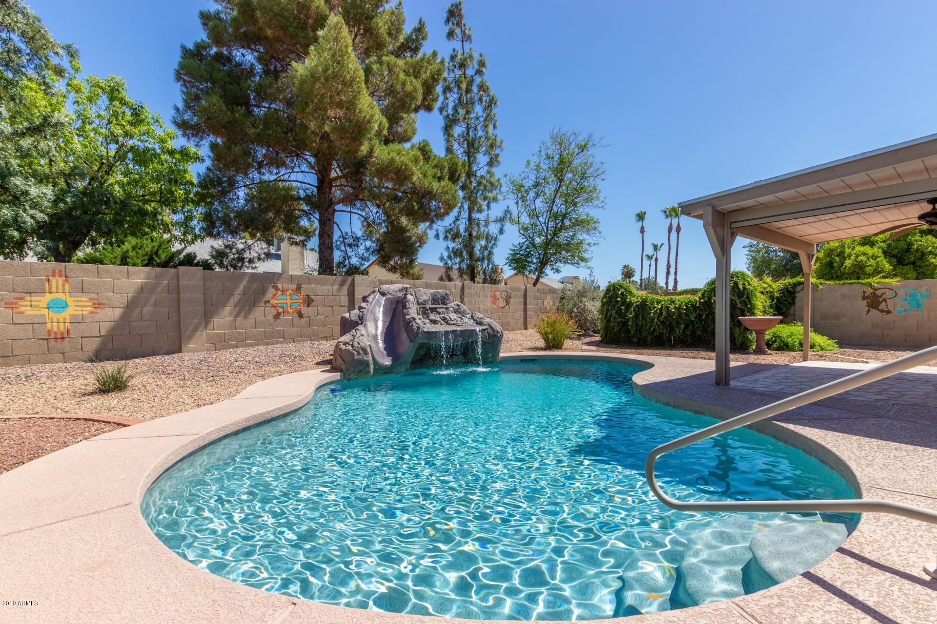 4812 East Gary Street Mesa, AZ 85205 - Photo 1 of 37 a view of a backyard with table and chairs potted plants and palm trees