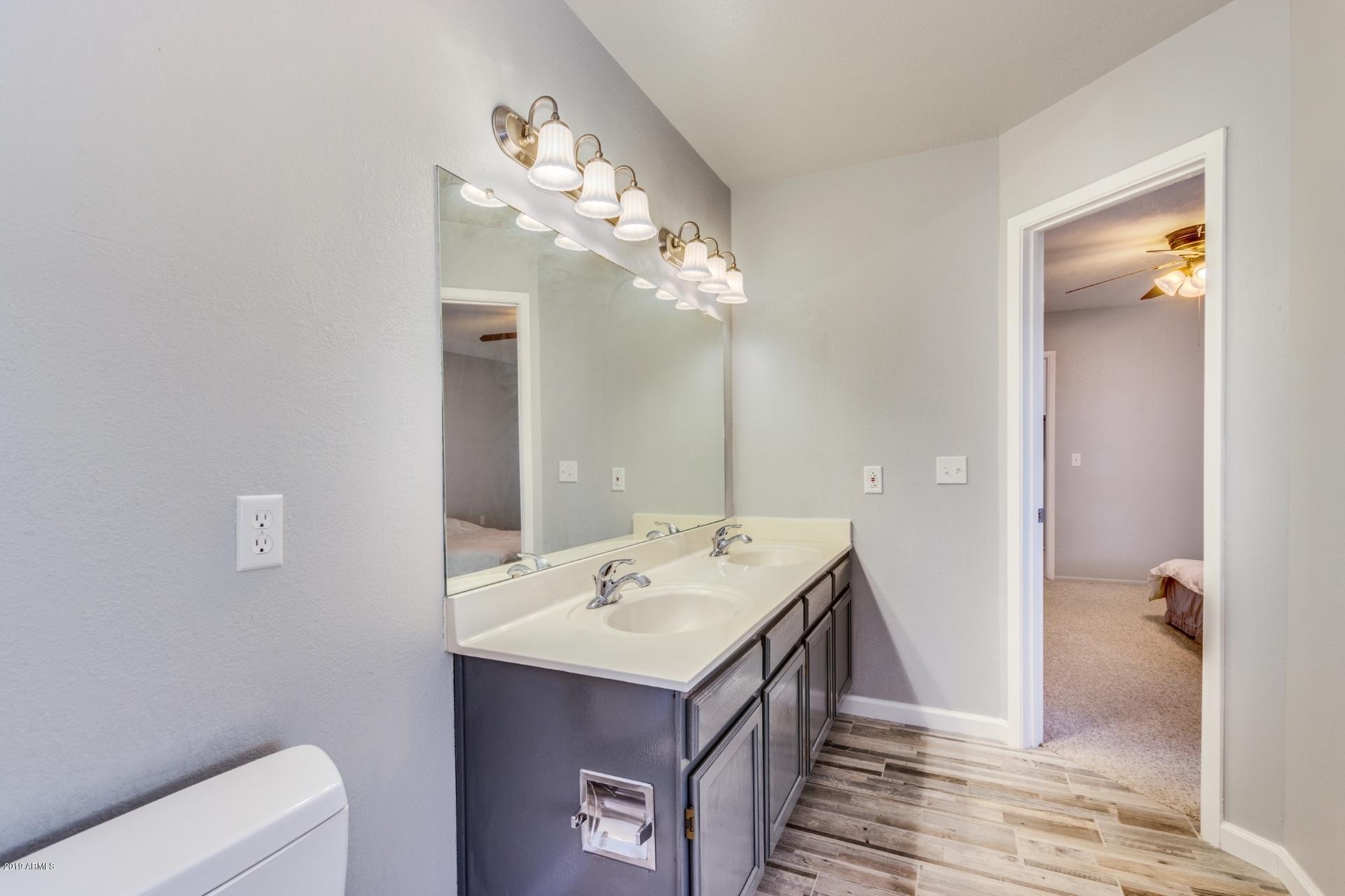 4812 East Gary Street Mesa, AZ 85205 - Photo 31 of 37 a bathroom with a sink a toilet and mirror